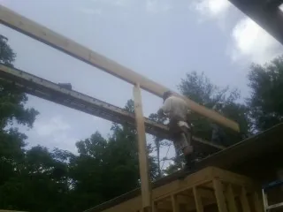 Carpenter setting a ridge beam over a new addition frame — Ice Dam Removal by Roofing Brothers in Homeworth