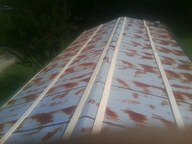Rusted metal roof panels with new wood purlins before replacement in Homeworth