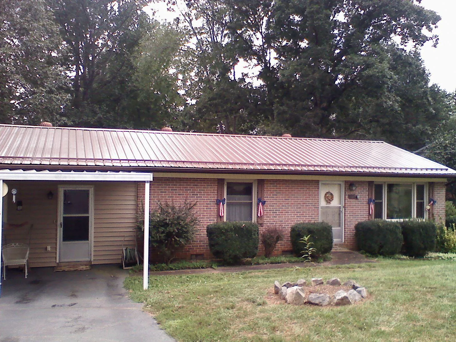 Bronze metal roof and carport on a brick ranch home — Roof Repair work by our crew in Homeworth